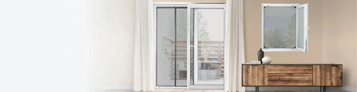 Eine Beige Wand mit Terrassentür vor der ein Insektenschutzgitter angebracht ist, daneben ein Fenster mit Fliegengitter und eine braune Kommode.
