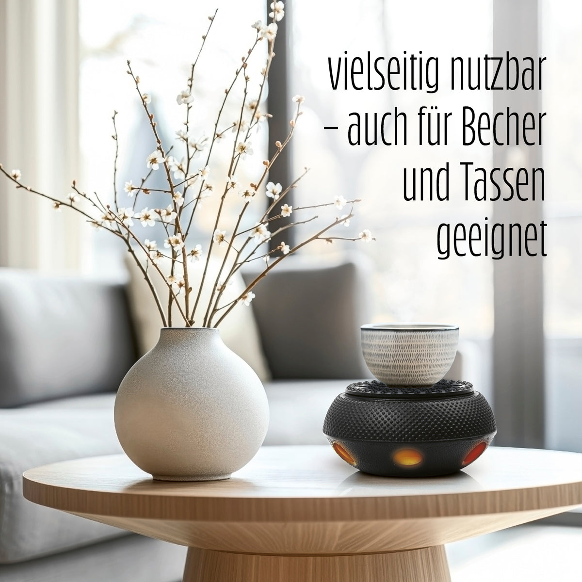 Stövchen aus Gusseisen - Teewärmer für Teekannen - Nach asiatischer Tradition - Schwarz mit Tasse auf einem Tisch neben Vase