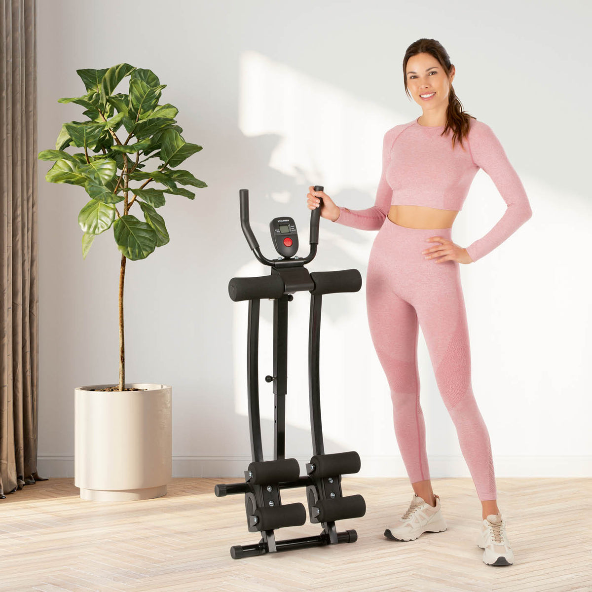 Frau im rosa Sportoutfit neben Trainingsgerät Abmaxx 6 mit 5 Schwierigkeitsstufen, höhenverstellbar und platzsparend zusammenklappbar