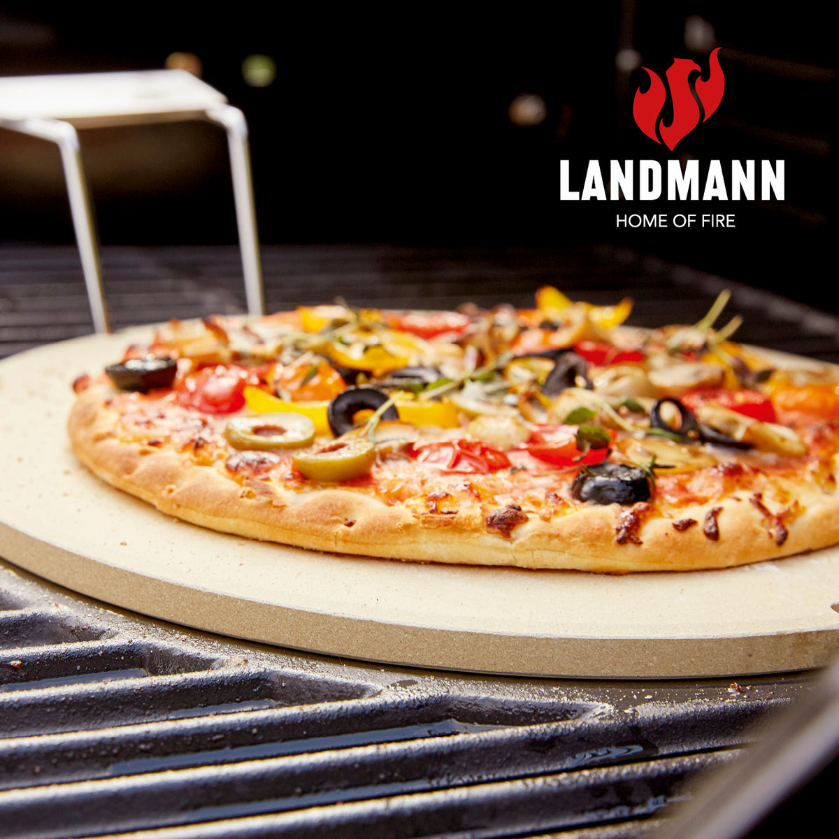 Pizzastein aus Cordierit auf Grill mit frischer Pizza, flexibel für Gasgrills, Holzkohlegrills und Backöfen einsetzbar.