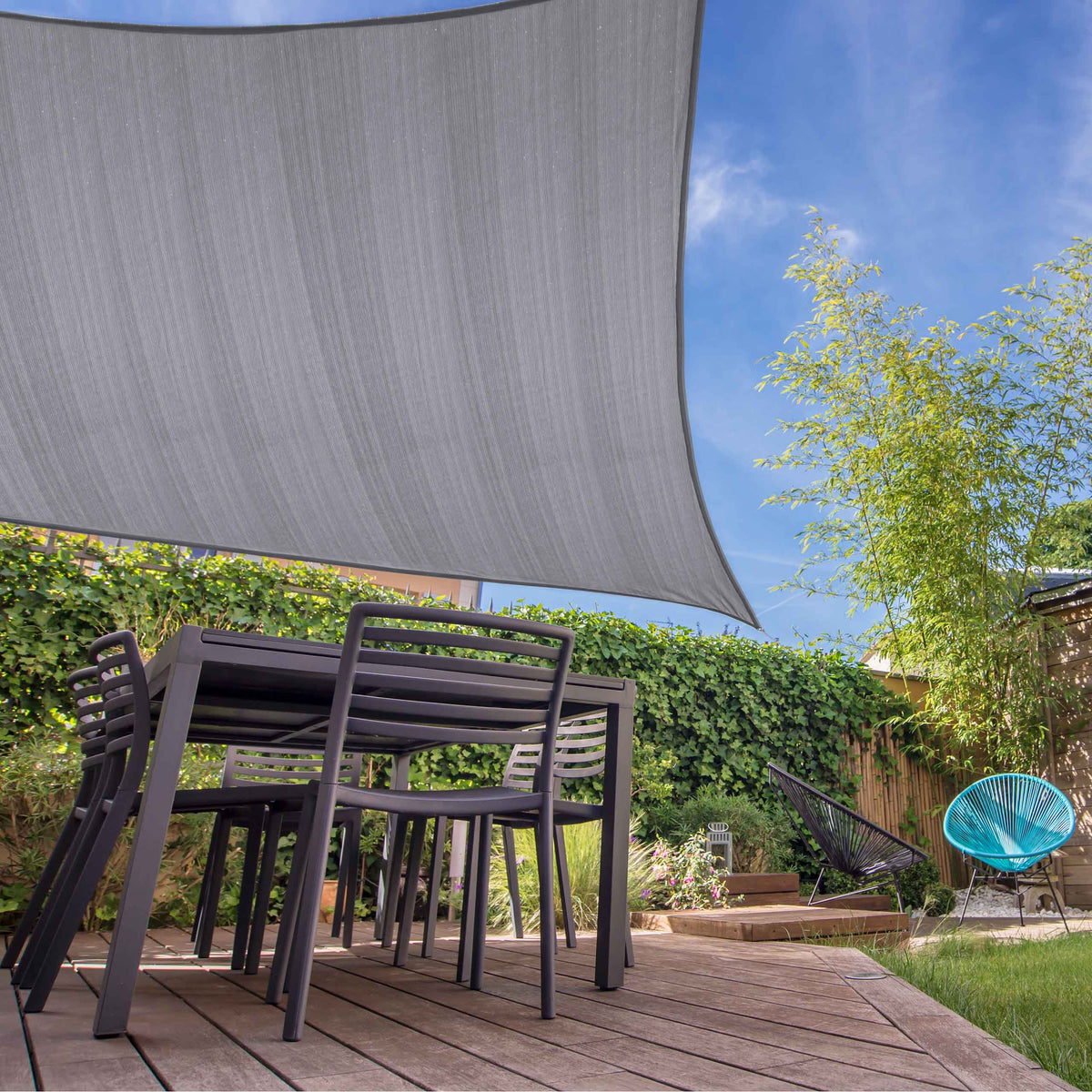 Sonnensegel 100% HDPE mit Stabilisator für UV-Schutz - Quadrat 4 x 4 Meter - Hellgrau über Gartenmöbeln auf Holzterrasse befestigt.