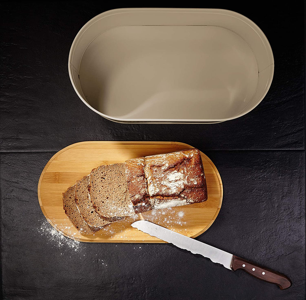 Cuisine Brotkasten aus Metall mit Bambus Deckel - Oval 36 x 20 x 13,8 cm in Grau mit Brotschneidebrett und frisch geschnittenem Brot.