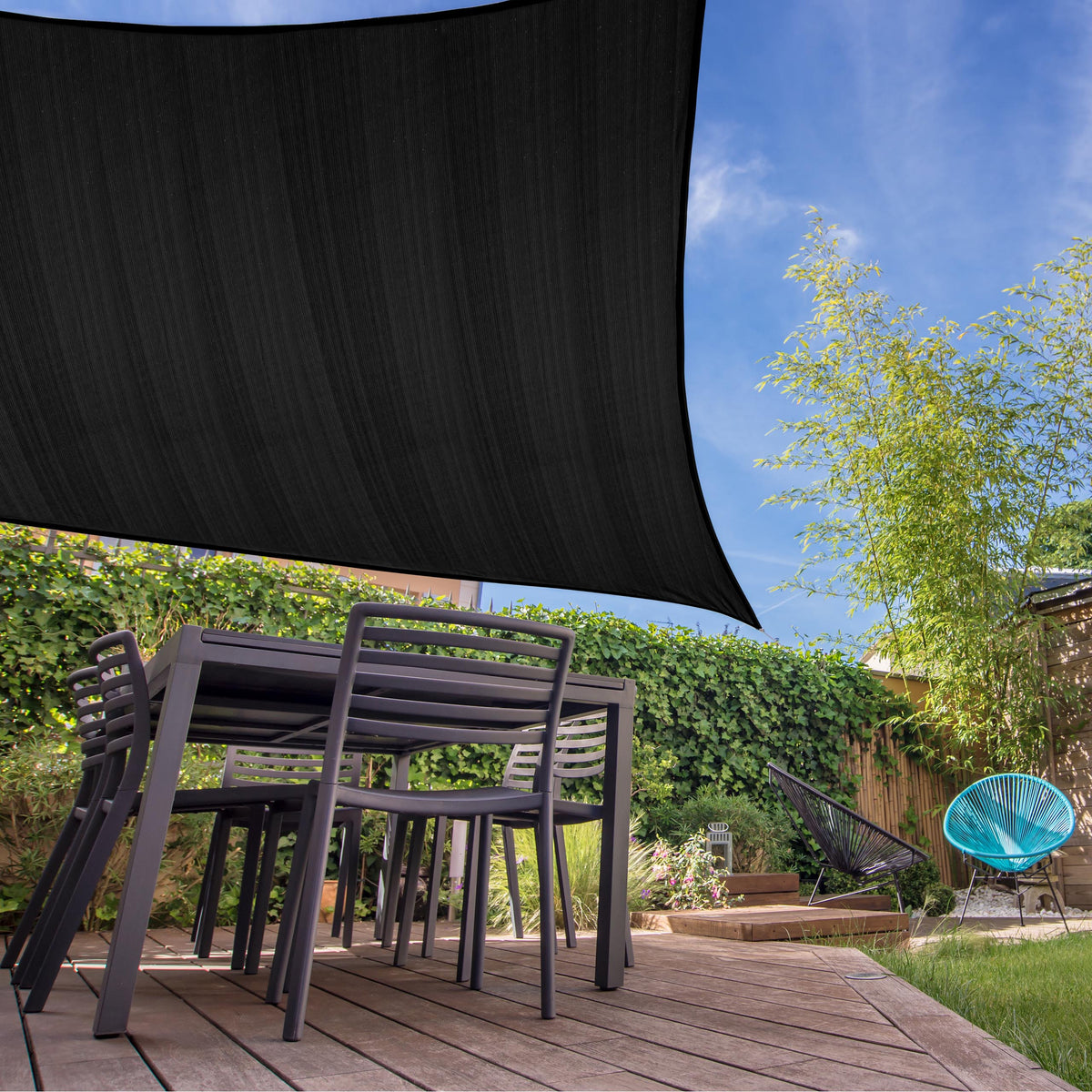 Sonnensegel 100% HDPE mit Stabilisator für UV-Schutz - Quadrat 4 x 4 Meter - Schwarz über Terrasse mit Gartenmöbeln montiert.