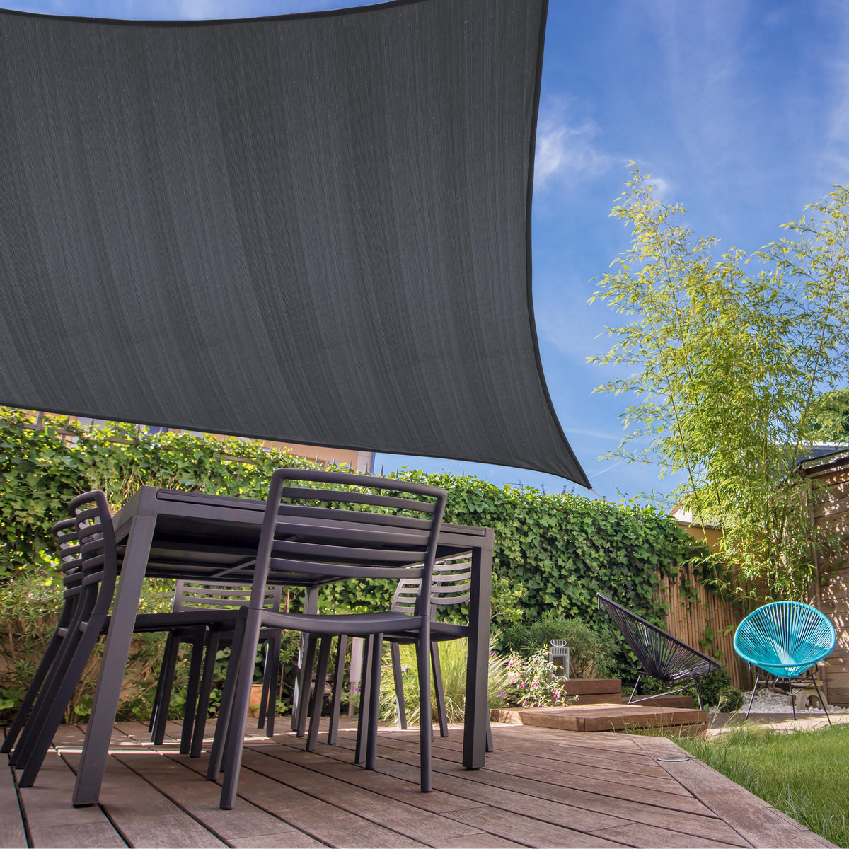 Sonnensegel 100% HDPE mit Stabilisator für UV-Schutz - Rechteck 2 x 3 Meter - Dunkelgrau über Terrasse mit Gartenmöbeln und Pflanzen.