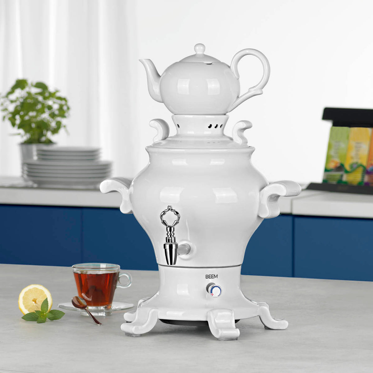ODETTE BLANC Samowar - 5 l in Weiß mit elegantem Design, integriertem Wasserhahn und Teekanne auf Küchenarbeitsplatte mit Teetasse.