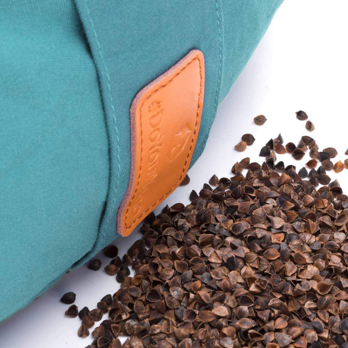 Bio-Buchweizenschalen zum Befüllen/Nachfüllen von Kissen & Bolstern - 2 kg neben türkisfarbenem Kissen