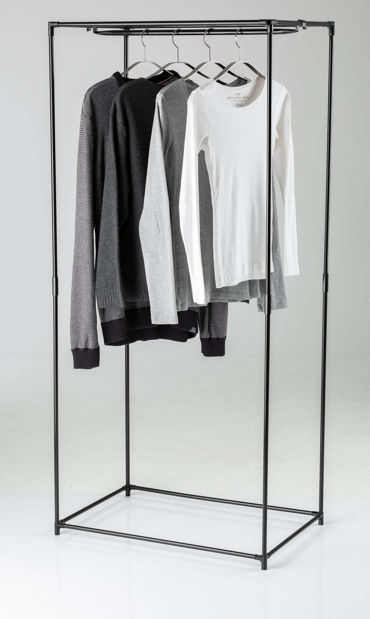 Stoffschrank mit Reißverschluss und Kleiderstange mit hängenden Pullovern und T-Shirts