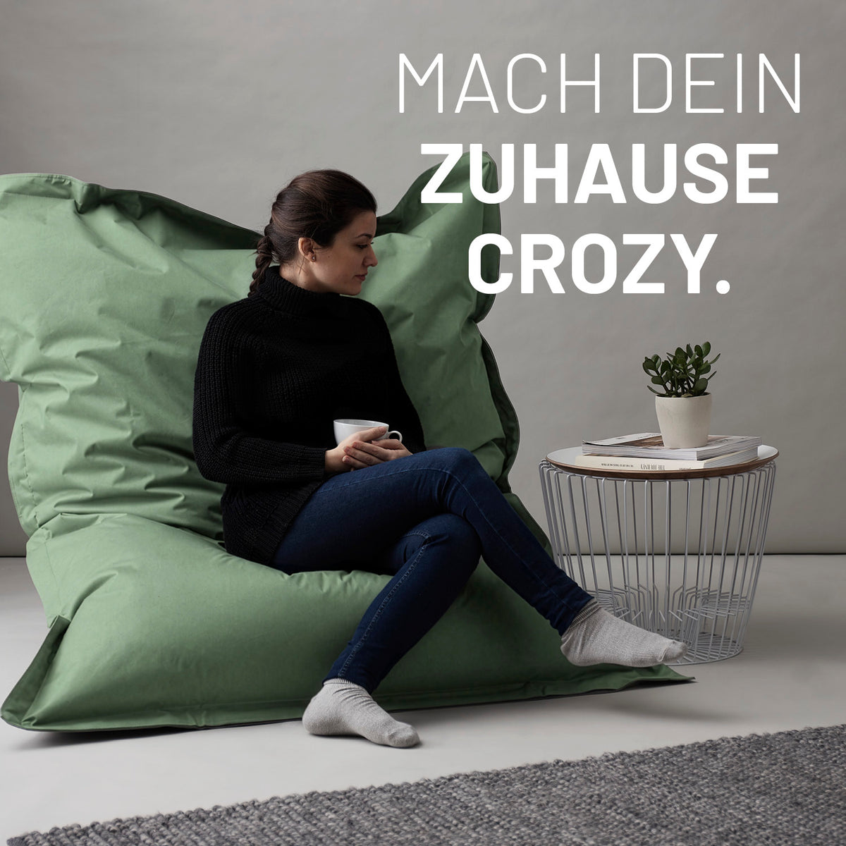 Frau entspannt auf dem Sitzsack Classic XXL (380 L) - indoor & outdoor - Pastell Grün mit bequemer Sitzhaltung und entspannter Atmosphäre.