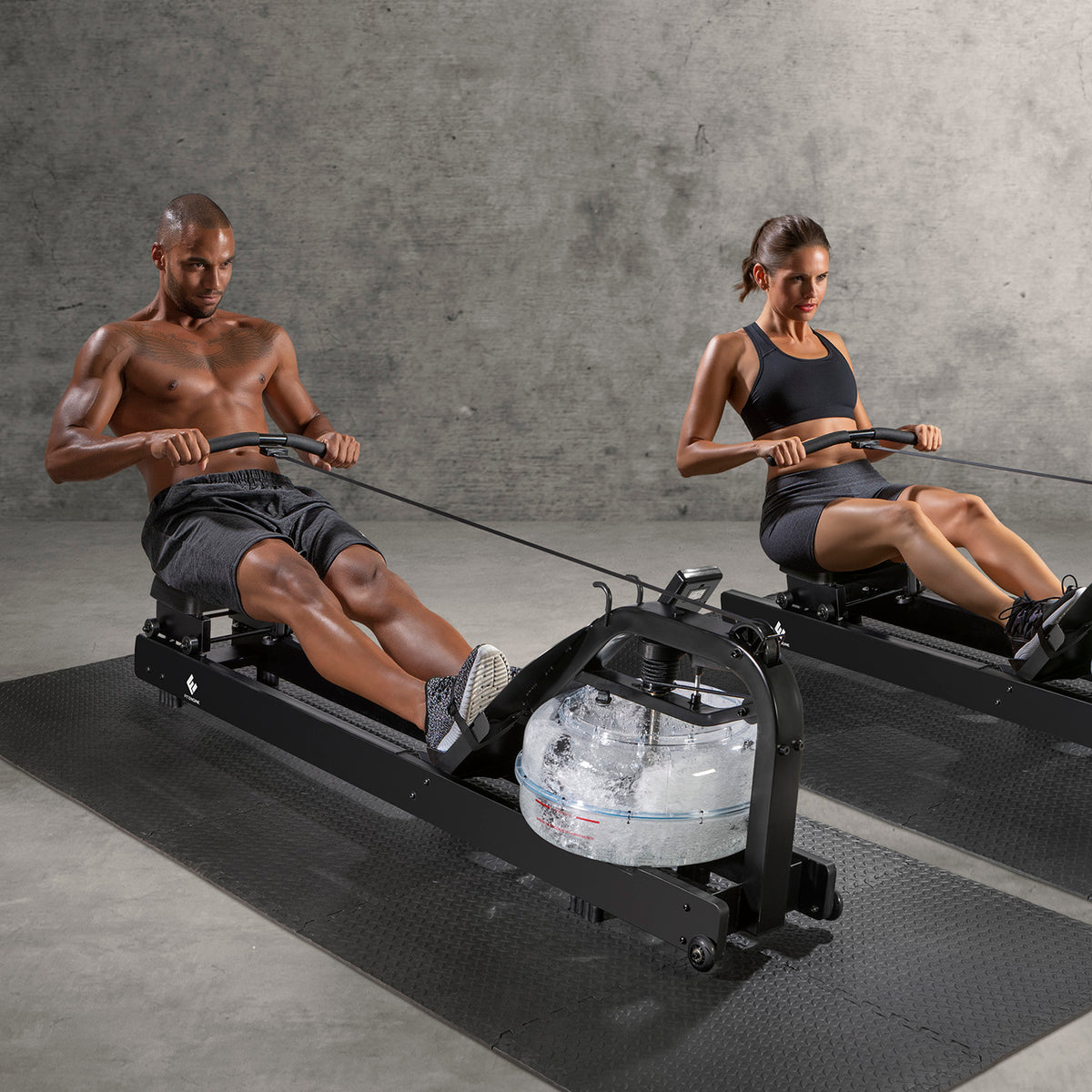 Zwei Personen trainieren auf dem Wasser-Rudergerät Smart - schwarz für ein effektives Ganzkörpertraining zuhause.