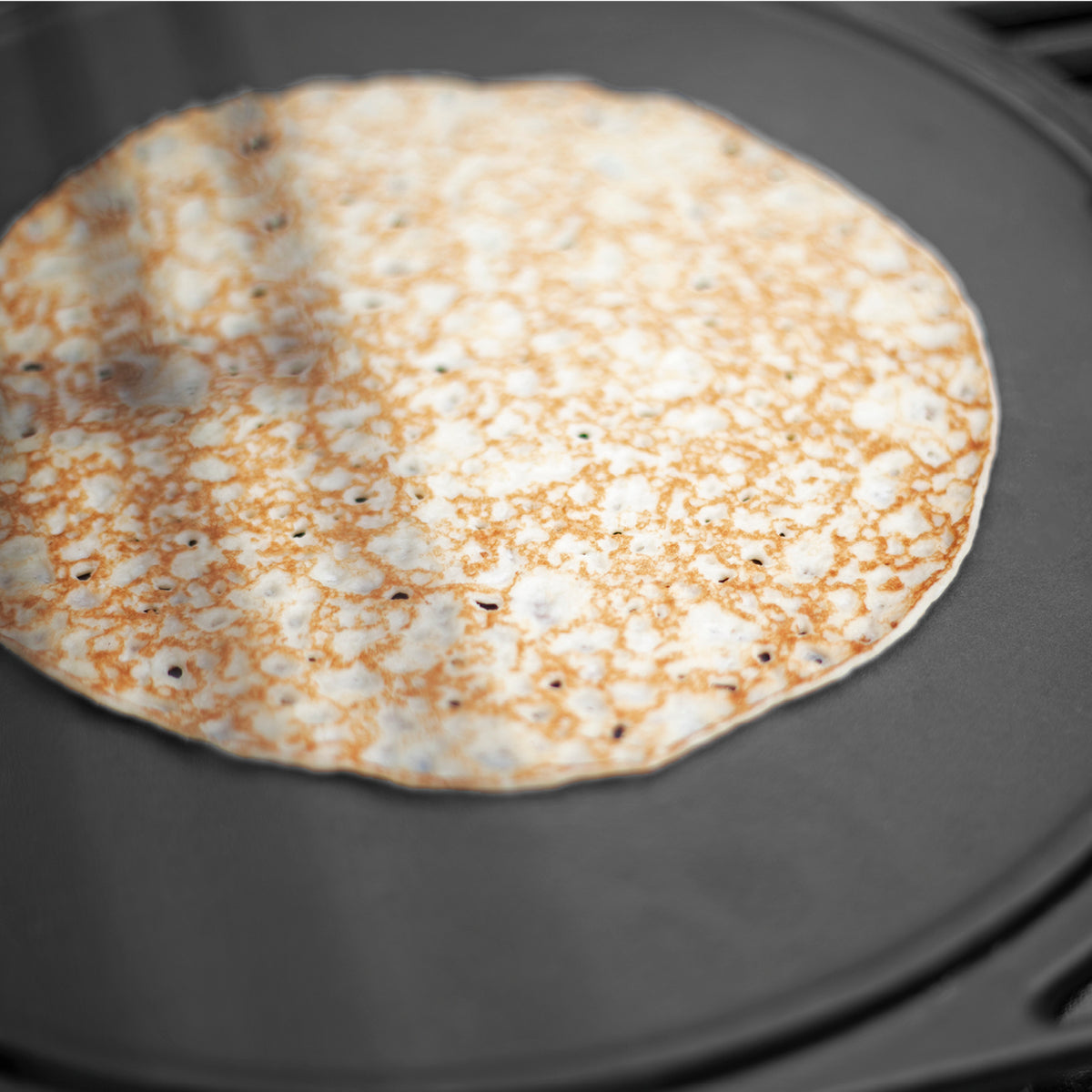 Wendeplatte Modulus - 30 x 39 cm mit Crêpe auf schwarzer, matt emaillierter Gusseisenfläche für optimale Hitzeverteilung und beidseitige Nutzung.