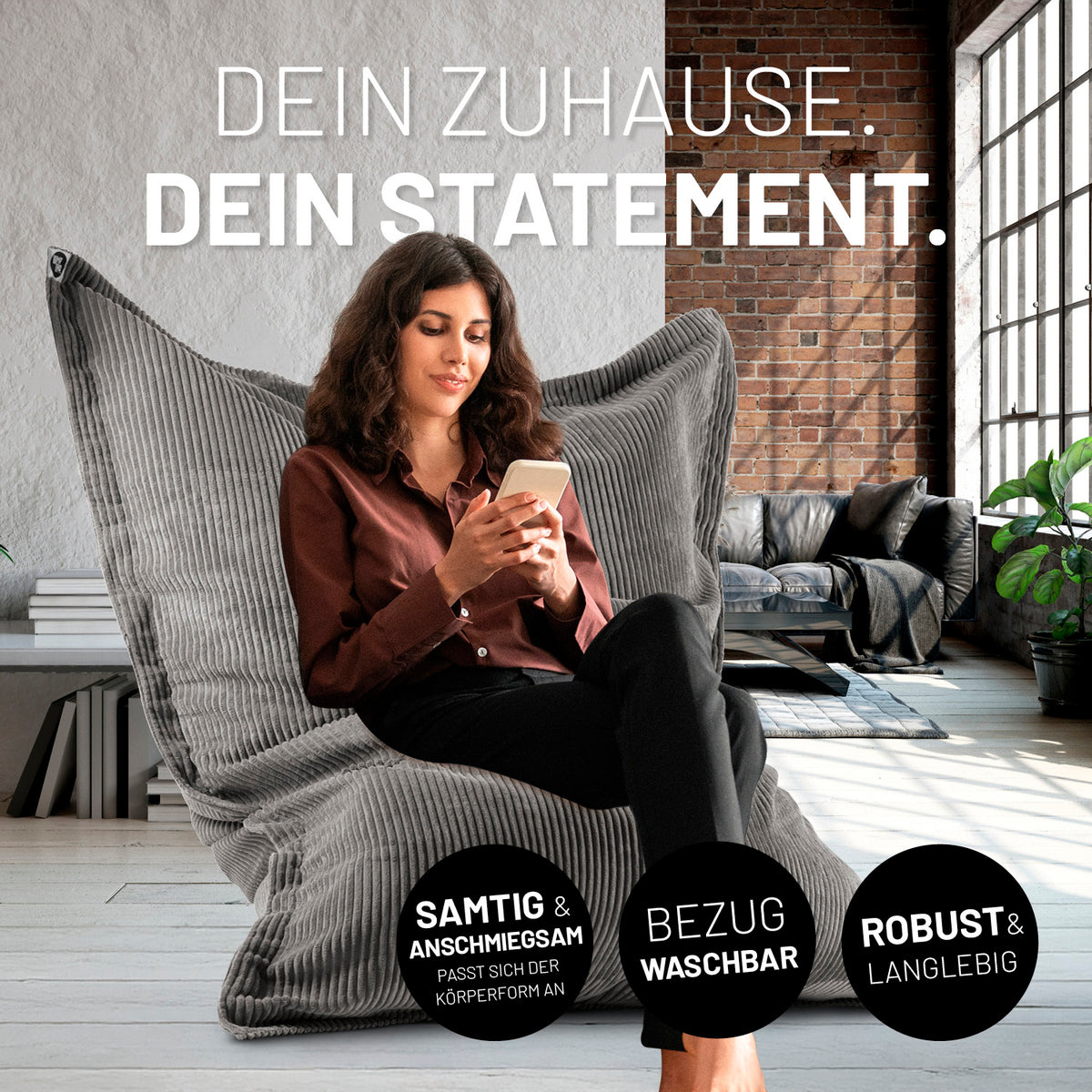 Frau sitzt entspannt auf Sitzsack Classic XXL aus der LUMALAND Cord-Reihe - 380 L - 140 x 180 cm - Grau in modernem Wohnraum.